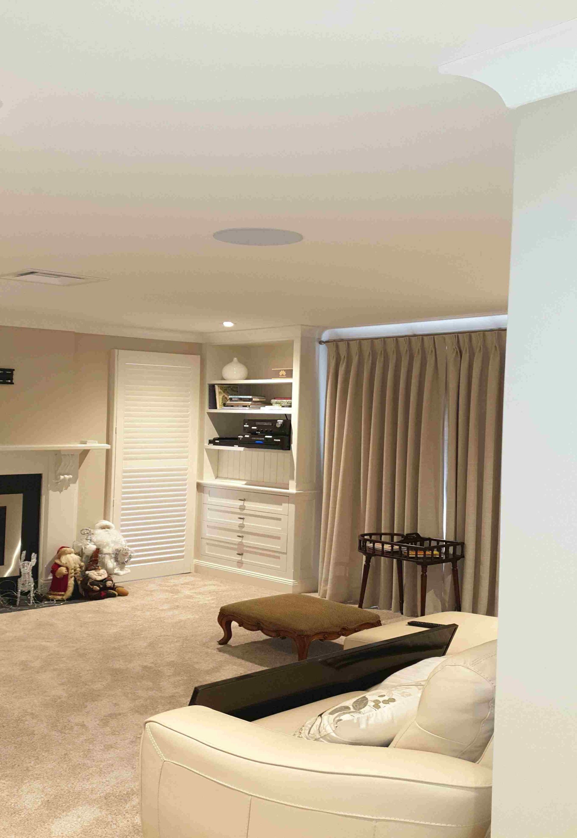 A living room with a couch , fireplace and ottoman.