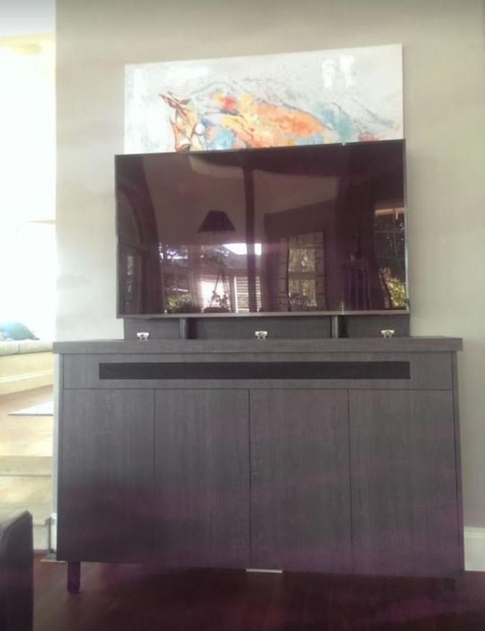 A flat screen TV is sitting on top of a wooden entertainment centre