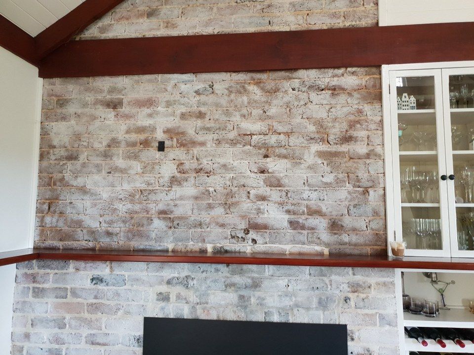 A living room with a brick wall and a fireplace