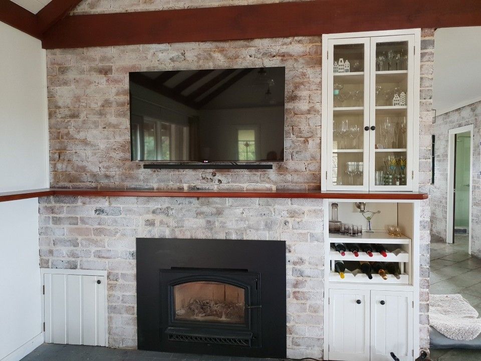 A living room with a fireplace and a flat screen TV.