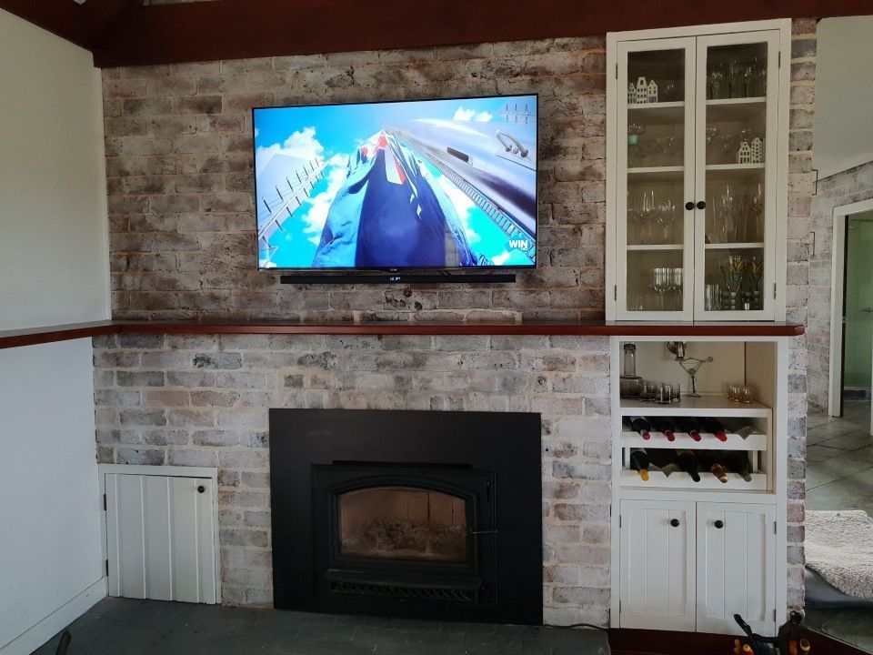 A living room with a fireplace and a flat screen TV.