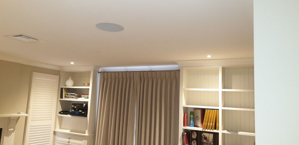 A living room with lots of shelves and curtains