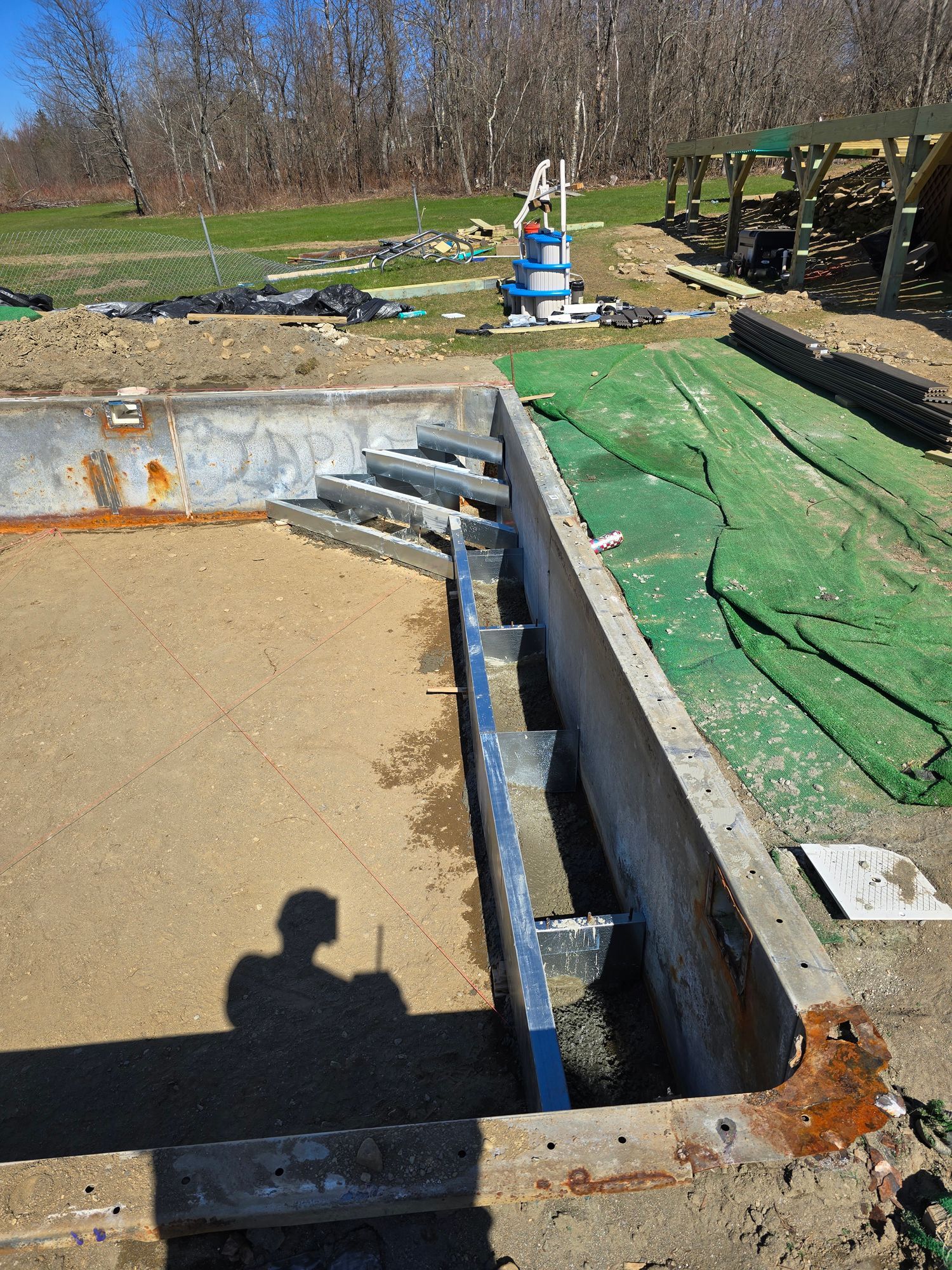 A concrete wall is being built around a swimming pool.