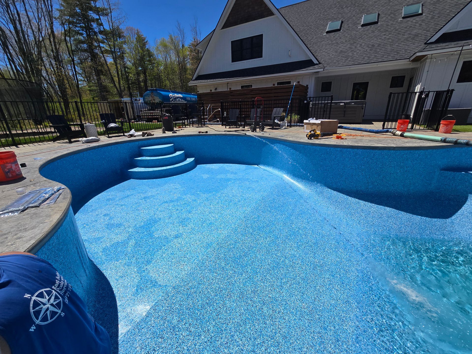 A large swimming pool is being built in front of a house.