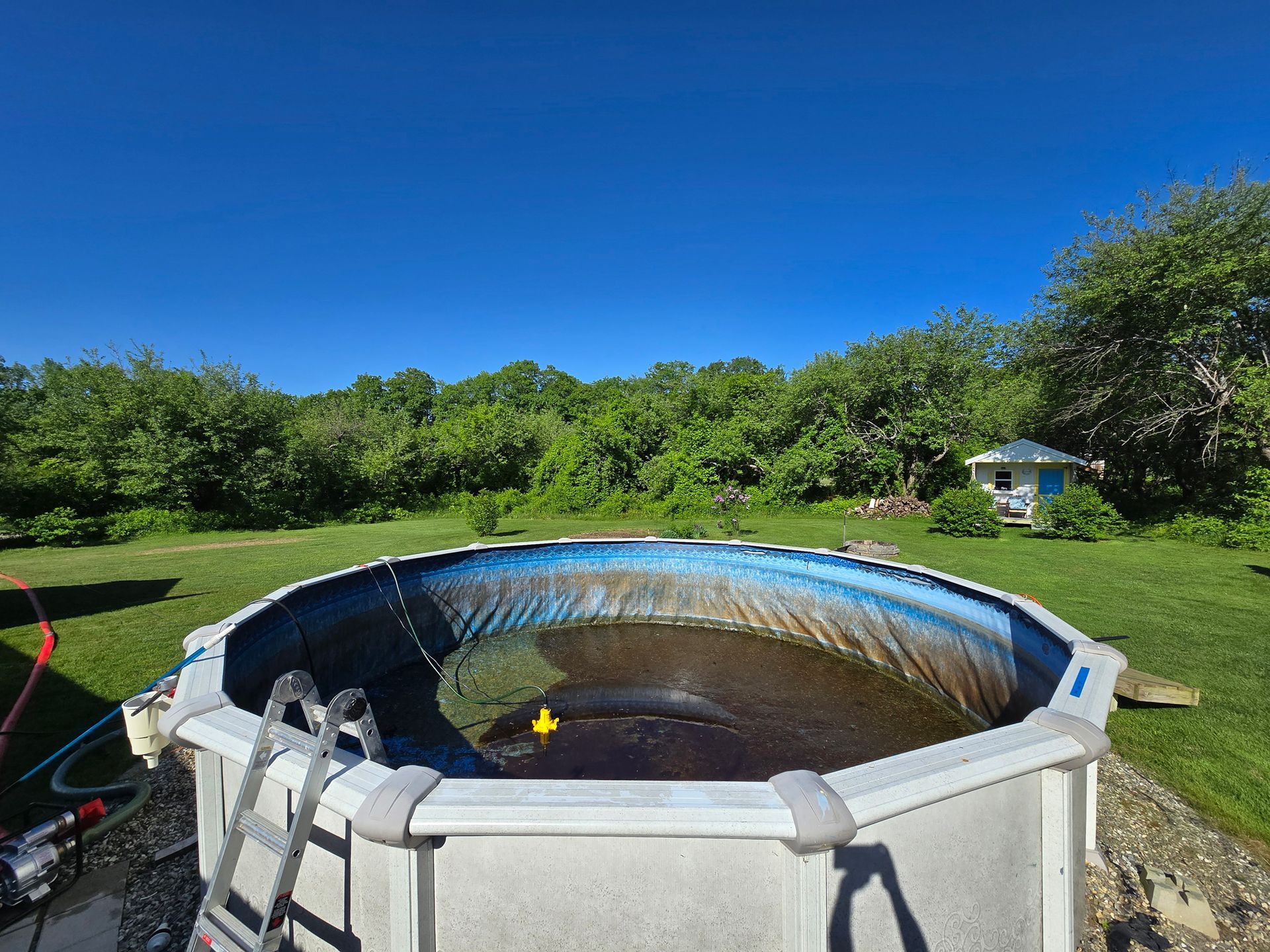 A swimming pool with a yellow rubber duck in it is being filled with water.