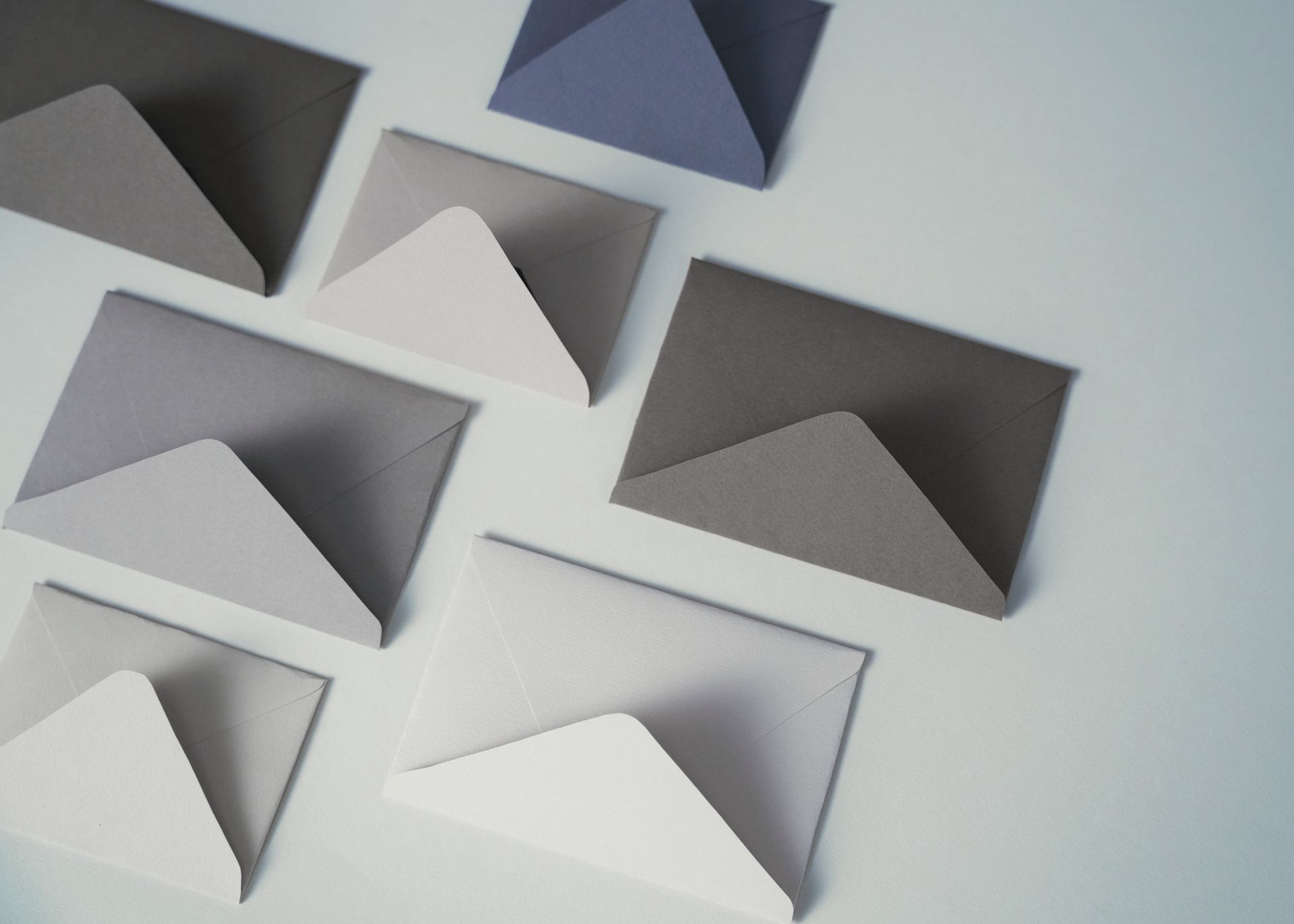 A group of envelopes are stacked on top of each other on a table.