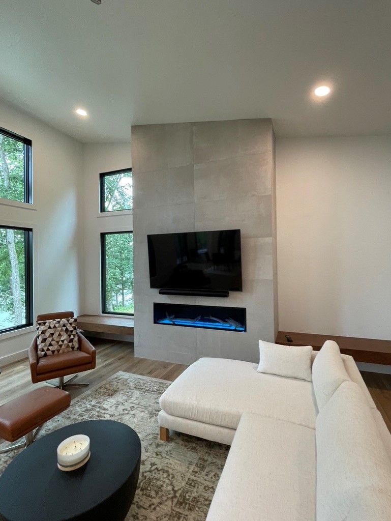A living room with a couch , chair , coffee table and television.