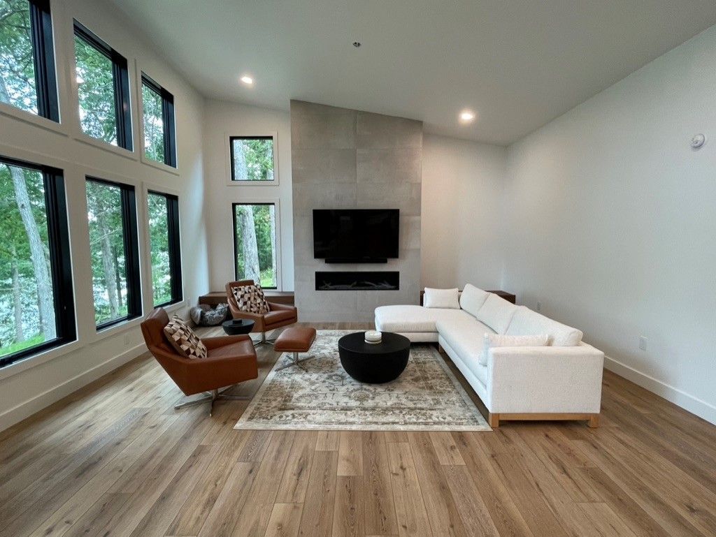 A living room with a couch , chairs , coffee table and television.