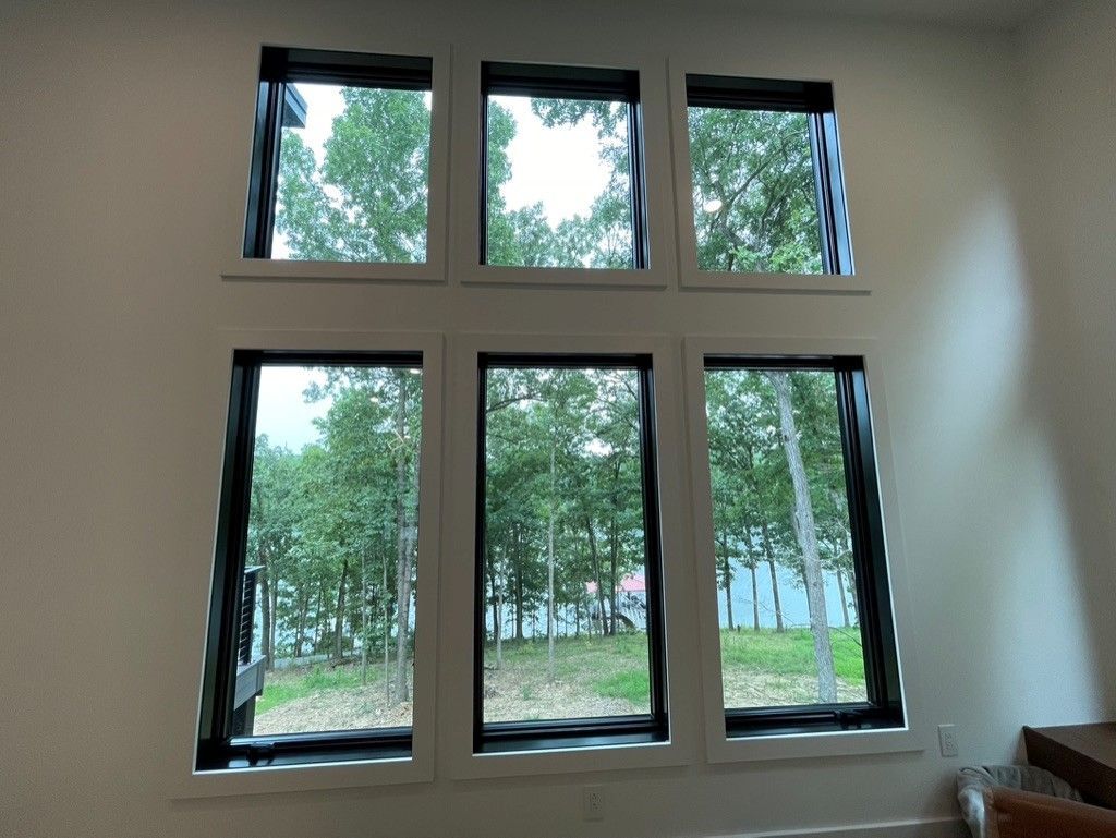 A room with a lot of windows and a view of trees.
