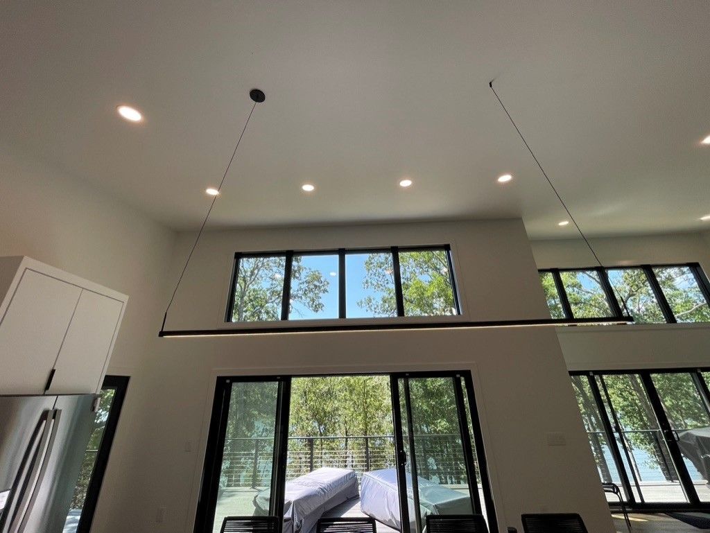 A living room with a lot of windows and a ceiling light.
