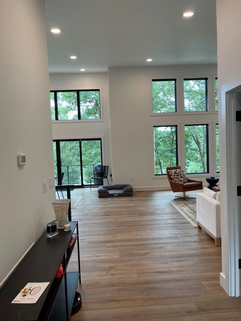 A living room with a lot of windows and a wooden floor.