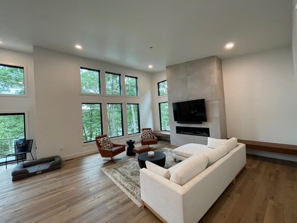 A living room with a couch , chairs , and a television.