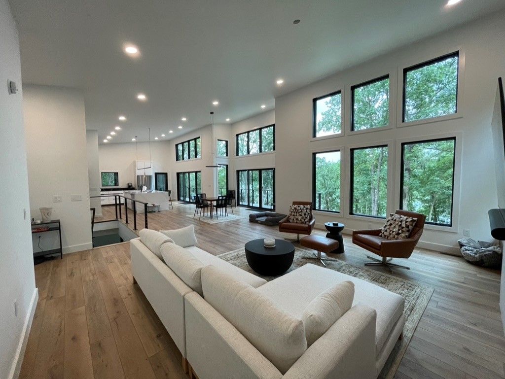 A living room with a couch and chairs and a lot of windows