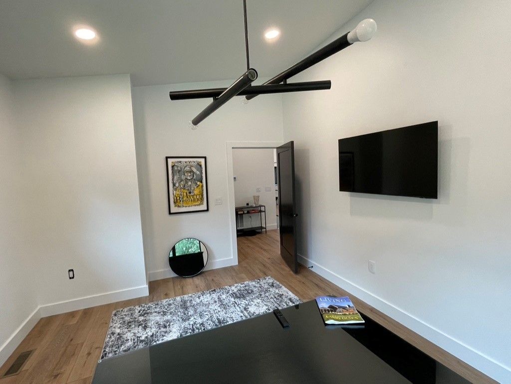 A living room with a flat screen tv on the wall.