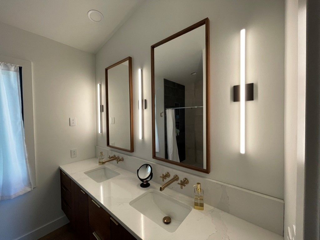 A bathroom with two sinks and three mirrors.