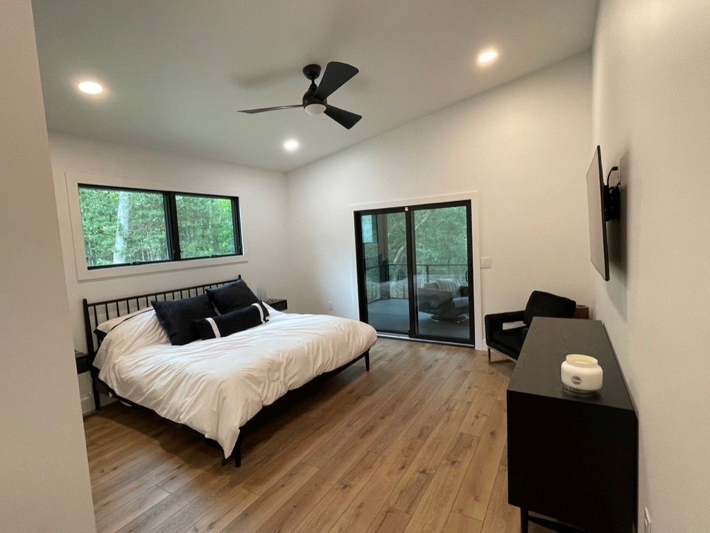 A bedroom with a large bed and a ceiling fan.