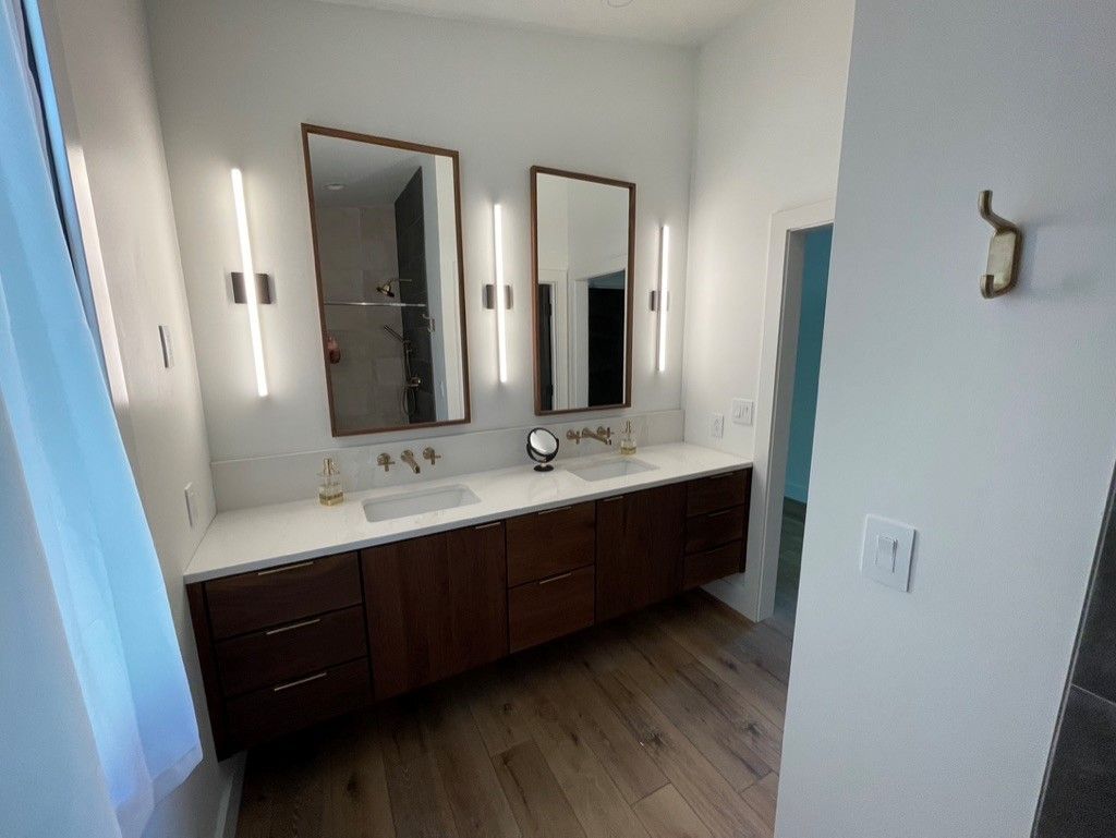 A bathroom with two sinks and two mirrors.