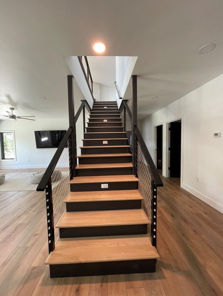 A wooden staircase with a metal railing in a living room.