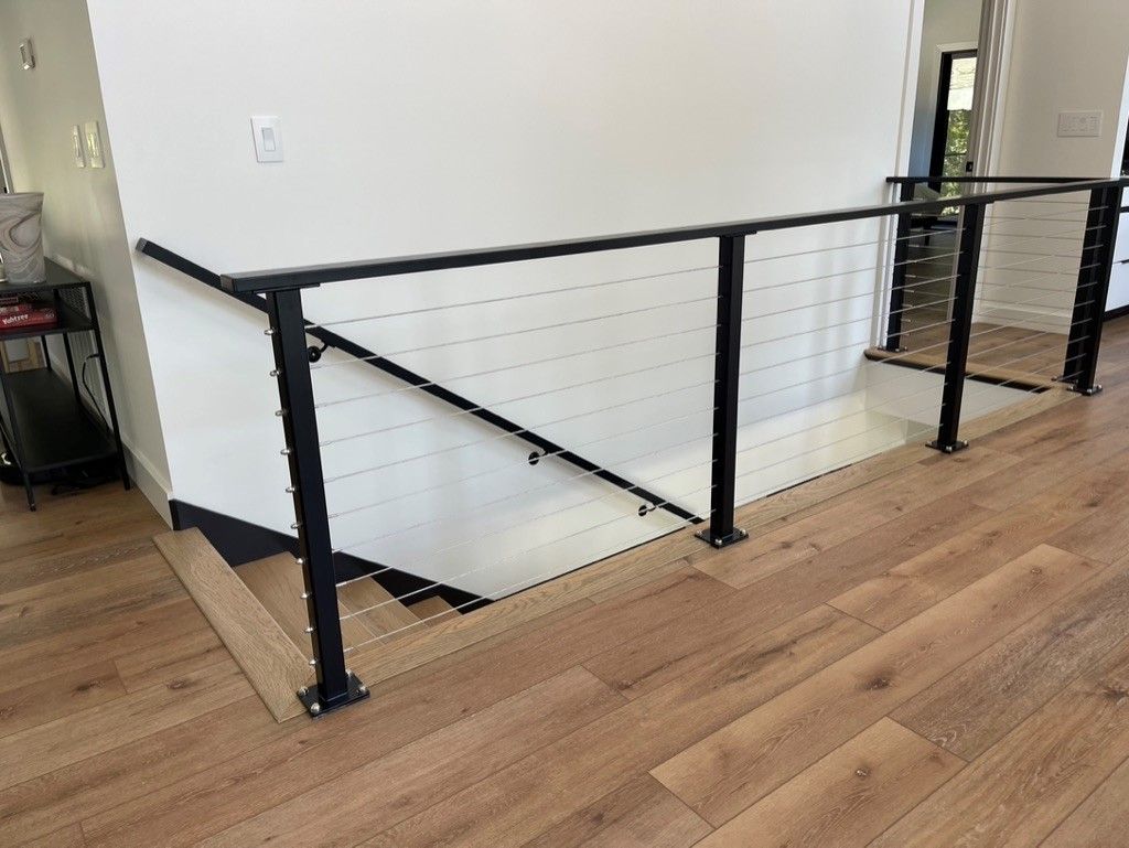 A staircase with a black railing and a wooden floor.