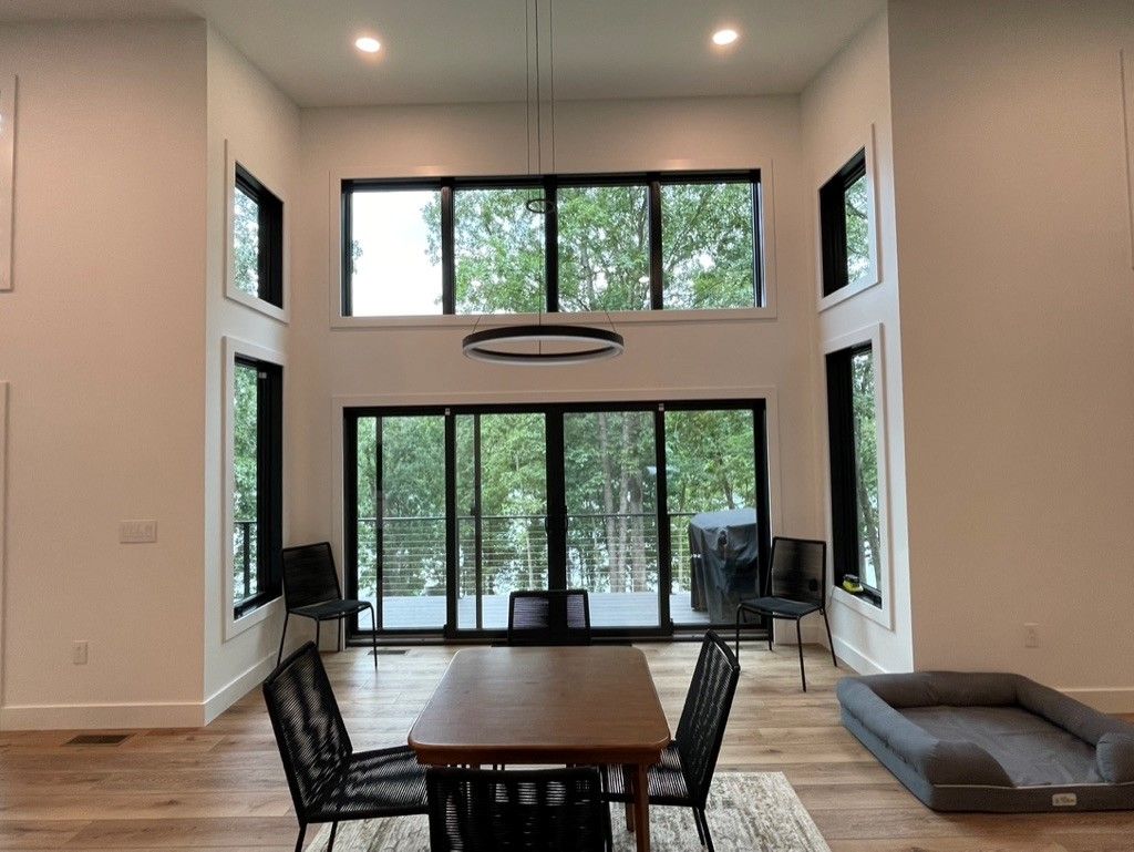 A dining room with a table and chairs and a dog bed.