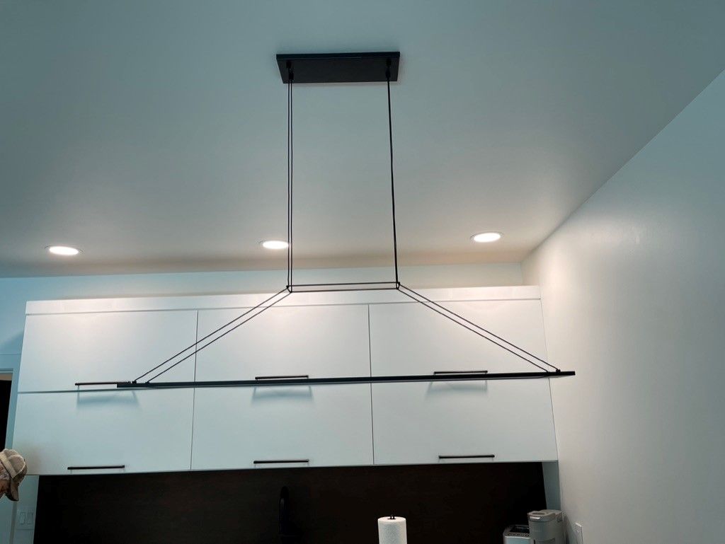 A light fixture is hanging from the ceiling in a kitchen.