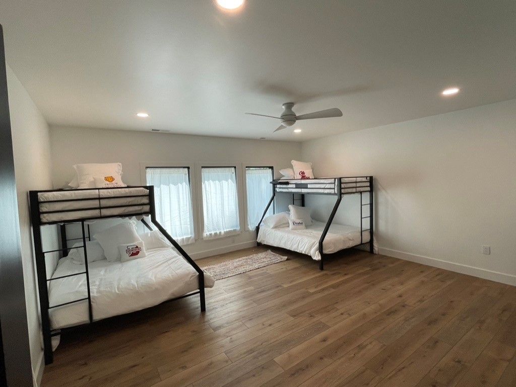 A bedroom with two bunk beds and a ceiling fan.