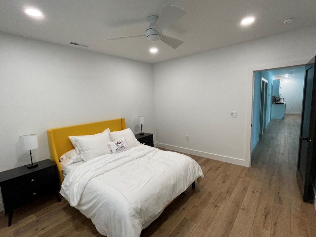 A bedroom with a large bed and a ceiling fan.
