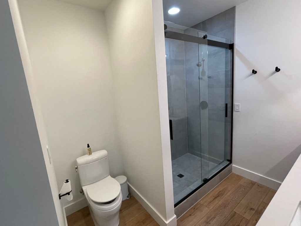 A bathroom with a toilet and a walk in shower.