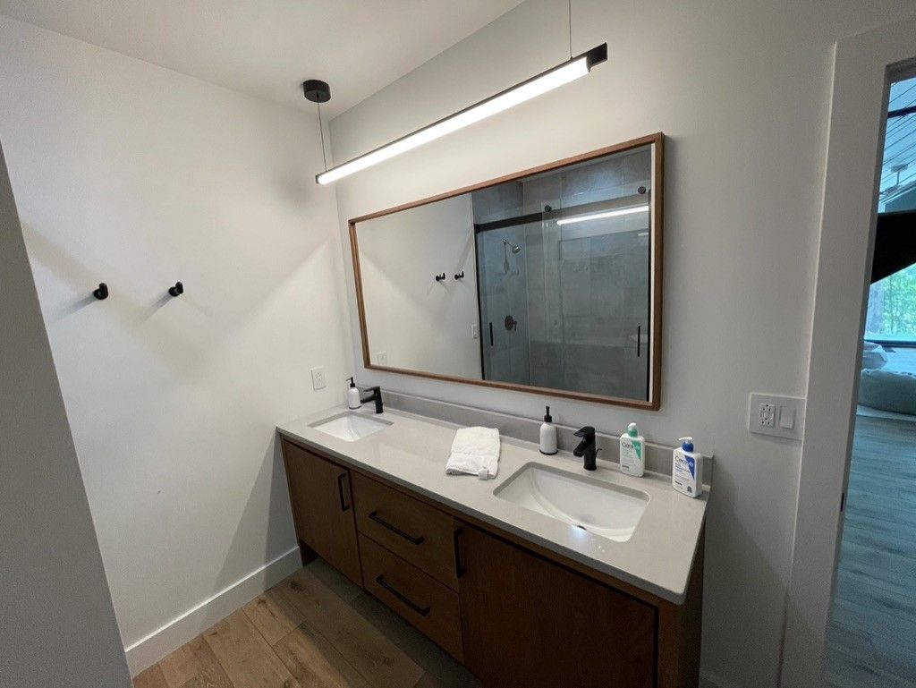 A bathroom with two sinks and a large mirror