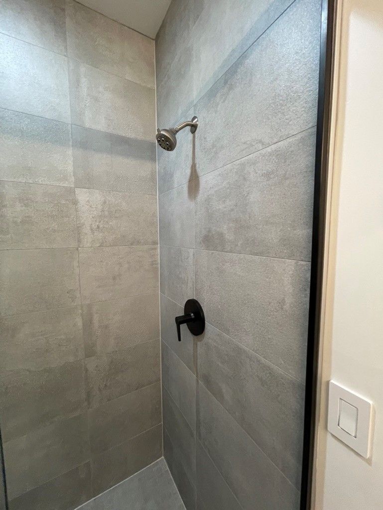 A shower with a shower head and a glass door.