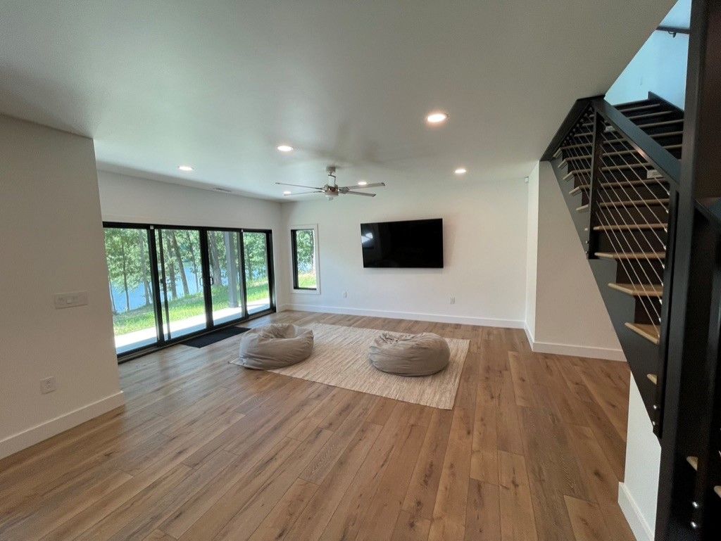 A living room with hardwood floors and a flat screen tv on the wall.