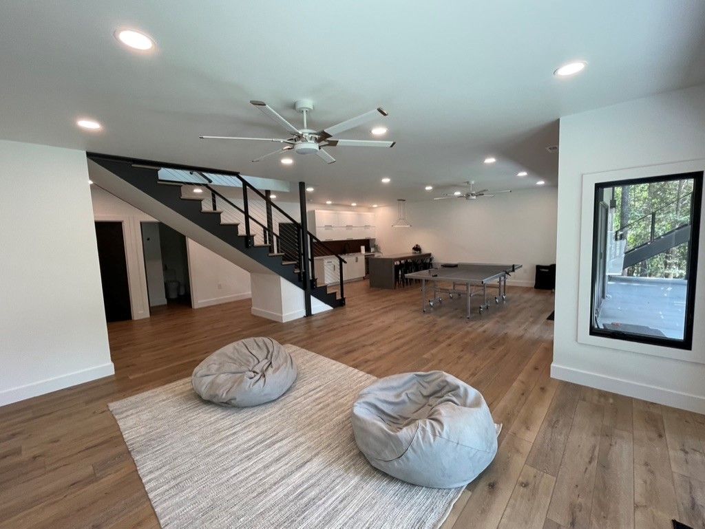 A living room with a staircase and a ceiling fan.