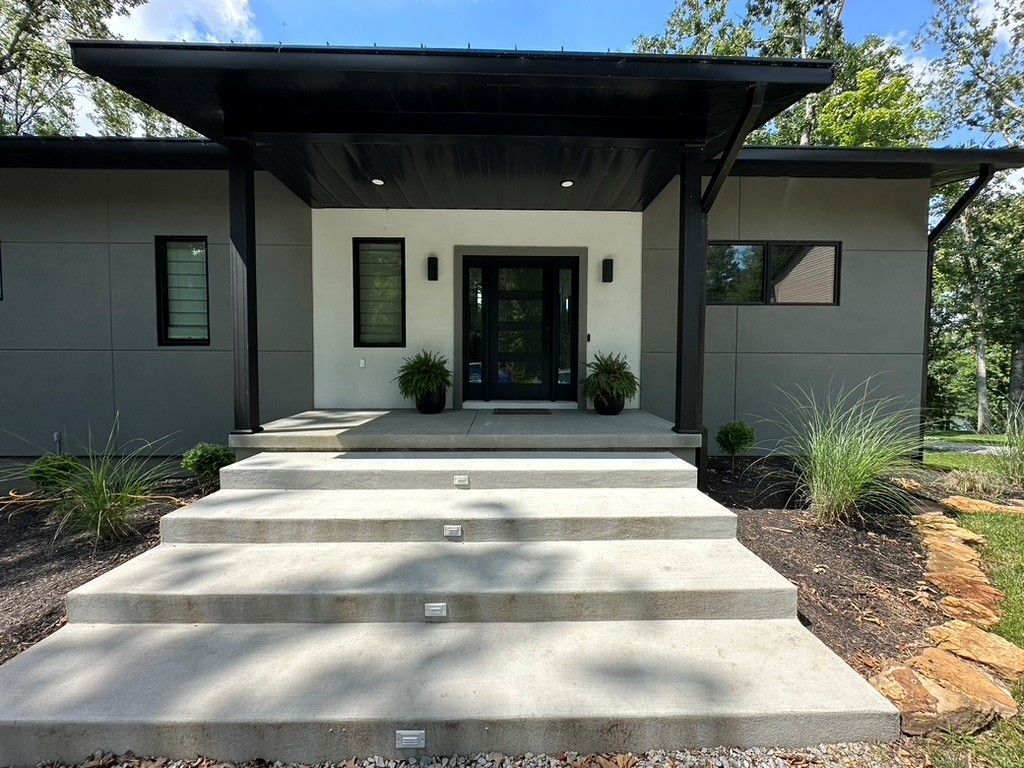 A modern house with concrete steps leading up to the front door