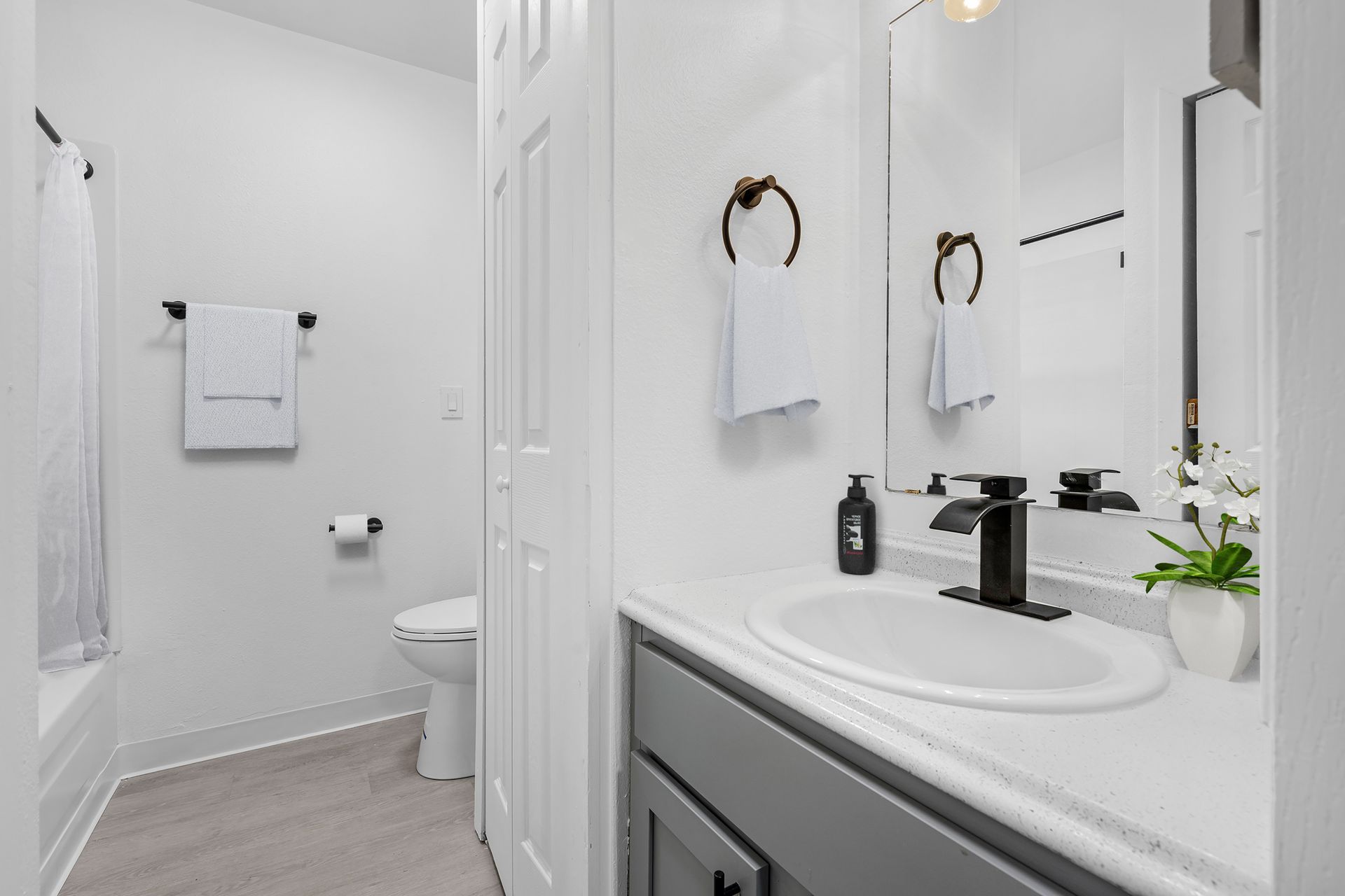 Photo showing a large bathroom with the bathtub/shower in the background