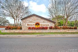 Braun Station sign made of stone with a brown roof, plants, and trees.