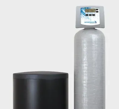 Two water treatment tanks: a black cylinder and a tall silver tank with a digital control head.