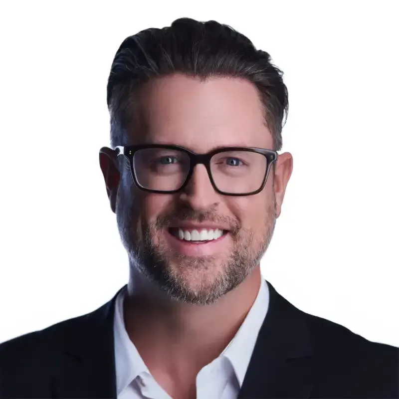 Smiling man in glasses and black blazer on a white background