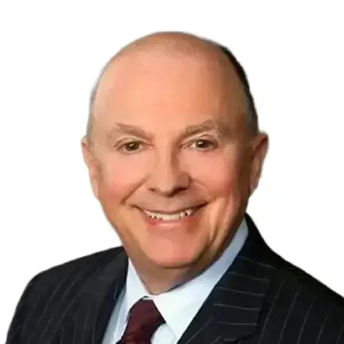 Smiling man in a dark pinstripe suit and maroon tie on a white background