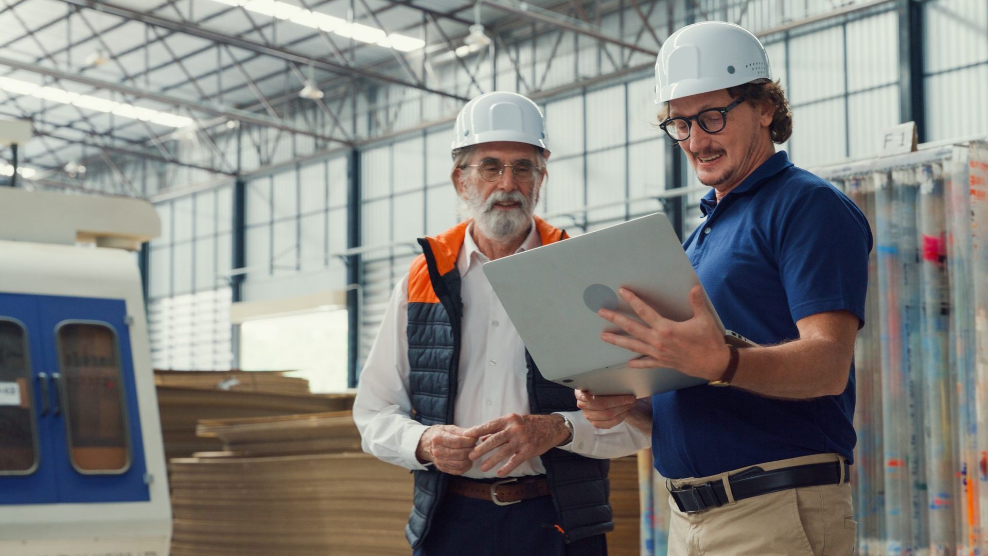 Two men in a factory reviewing safety data