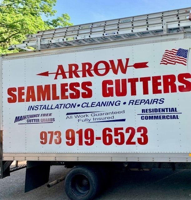 Arrow Seamless Gutters truck side with red logo, services, and phone number 973-919-6523