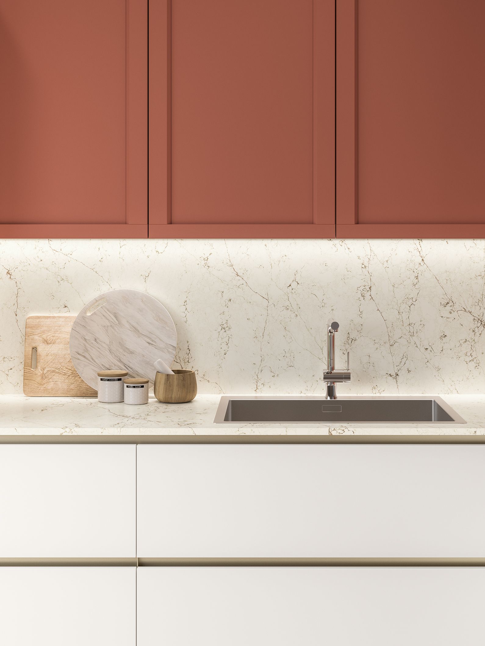 Cucina con pensili color terracotta, pensili bianchi, paraschizzi maculato e lavello in acciaio inossidabile.