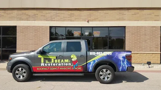 A truck is parked in front of a brick building.