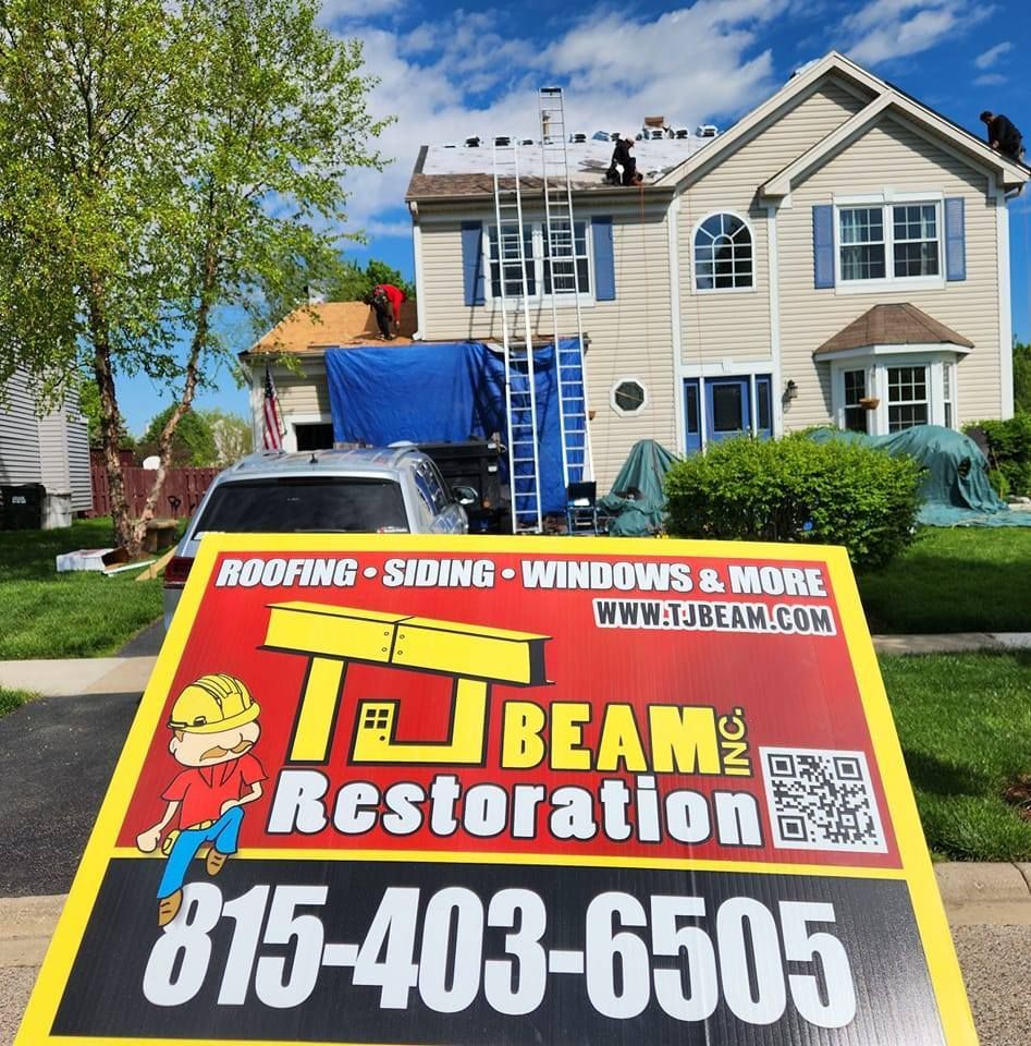 A sign for j beam restoration is in front of a house