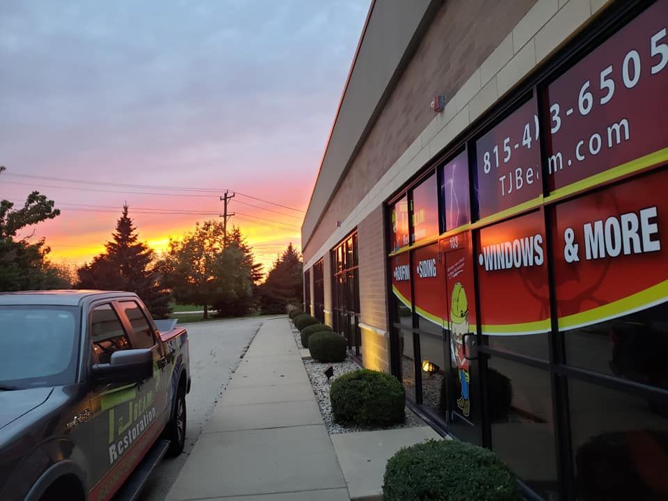 A truck is parked in front of a building that says windows and more
