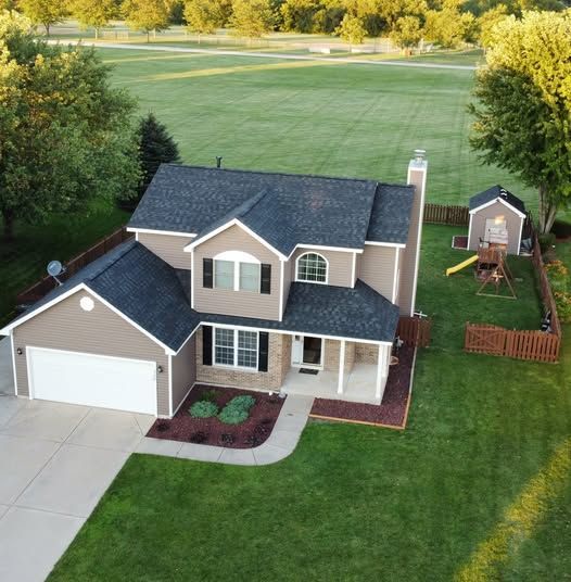 An aerial view of a house with a large driveway
