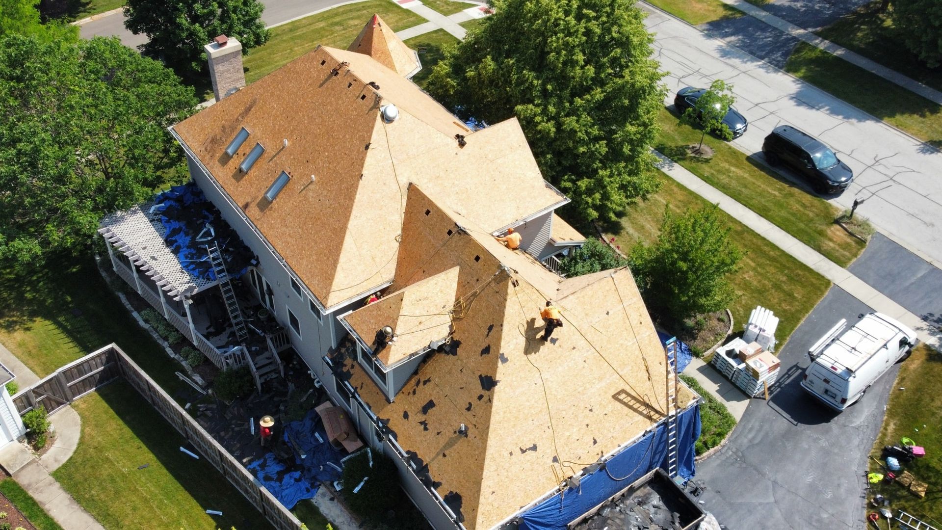 An aerial view of a house with a roof being repaired.