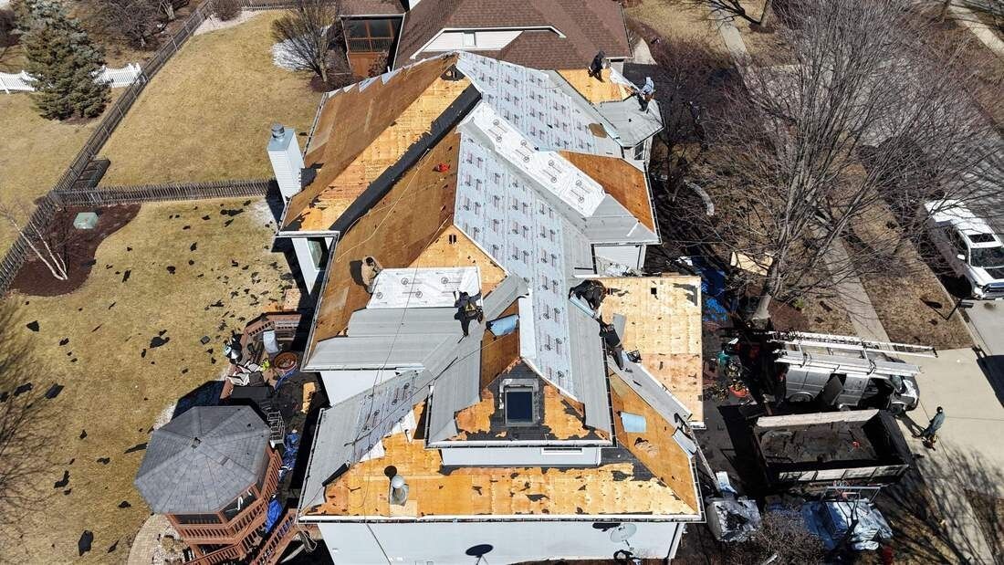 An aerial view of a house with a roof that is being repaired.