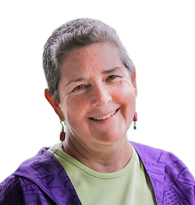Smiling person with short gray hair, wearing a purple jacket and light green shirt on a white background