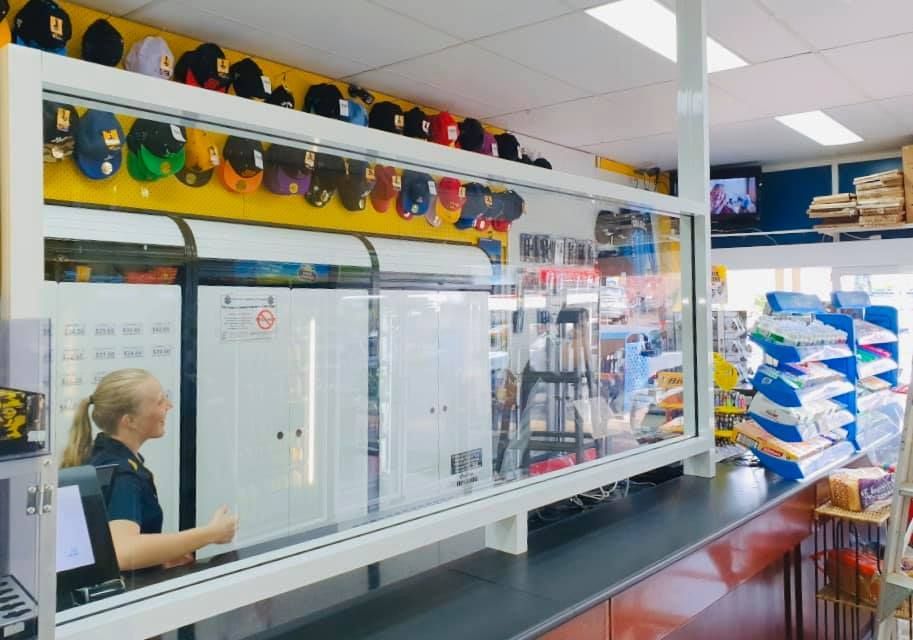 A Store Counter With a Cashier Behind a Protective Glass — Innisfail Glass & Aluminium in Mission Beach, QLD