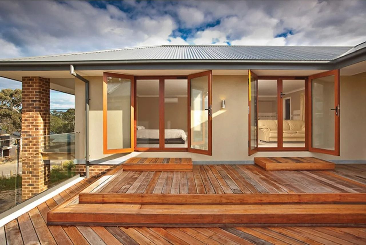 Wooden Deck With Open Folding Doors Overlooking a Bedroom — Innisfail Glass & Aluminium in Innisfail, QLD